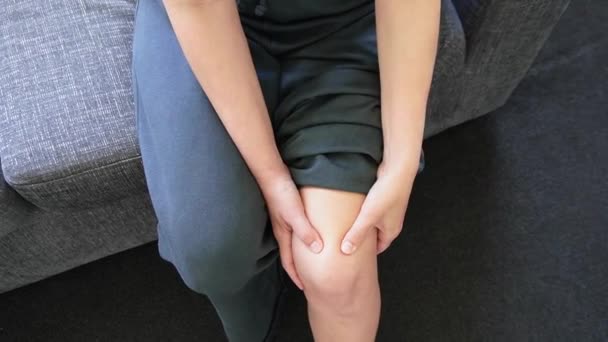 Osoba masírující si kolena při ohýbání a rozhýbání kolena, pociťující bolest způsobenou bursitidou, artritidou nebo zánětem šlach - Záběry, video