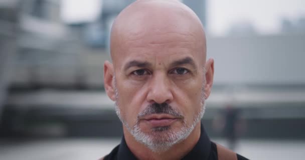 Close-up confident man with goatee and bald head looking straight into camera. Confident look and firm posture radiate strength and determination. Confident appearance impressive man attracts eye - Footage, Video