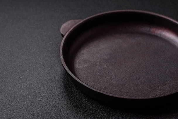 Empty ceramic round plate on dark textured concrete background. Cutlery, preparation for dinner - Фото, изображение