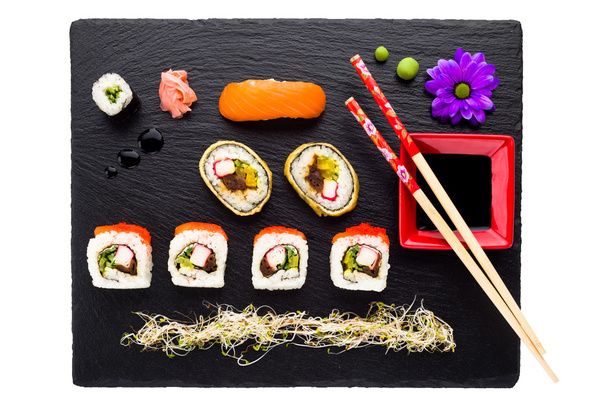 Sushi on black stone plate isolated top view - Photo, Image
