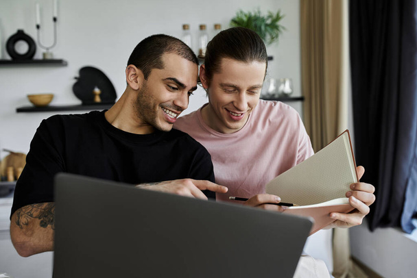 Mladý homosexuální pár sdílí něžný moment při čtení knihy ve svém moderním domově. - Fotografie, Obrázek