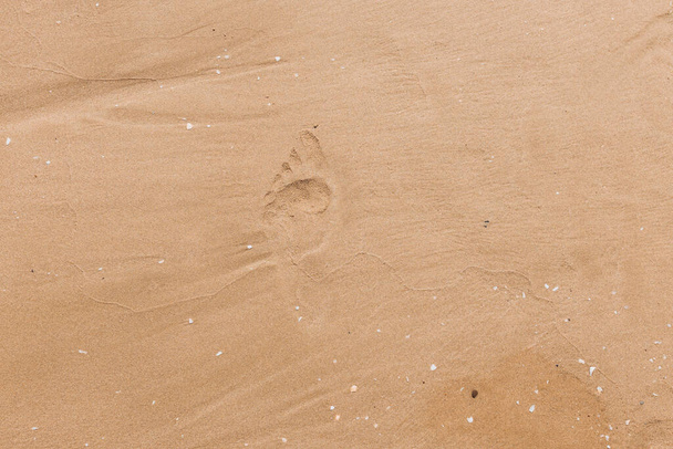 Huellas humanas en la arena clara de la playa. textura de la superficie de arena, - Foto, imagen
