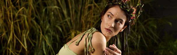 A woman in a green dress poses in a swampy environment. - Photo, Image