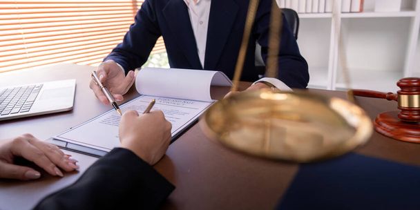 Un abogado profesional que firma un contrato comercial con un cliente en un entorno de oficina, que simboliza el acuerdo legal y la asociación empresarial. - Foto, Imagen
