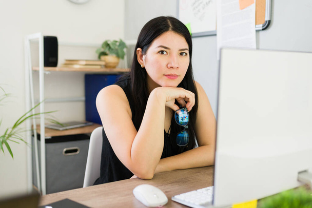 Εμπιστευτική νεαρή γυναίκα επιχειρηματίας που εργάζονται και να κάνει οπτική επαφή σε ένα σύγχρονο επιχειρηματικό περιβάλλον εκκίνησης γραφείο - Φωτογραφία, εικόνα