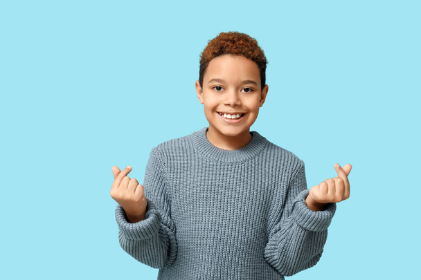 Roztomilý malý afroameričan ukazující na modrém pozadí gesto srdce. Valentýnská oslava - Fotografie, Obrázek
