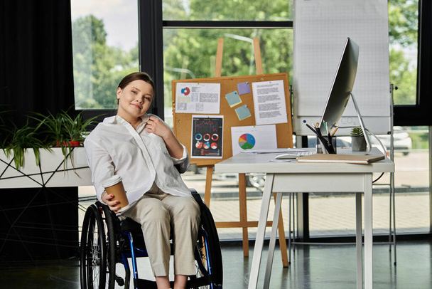 Una joven empresaria en silla de ruedas trabaja en una oficina moderna. - Foto, Imagen
