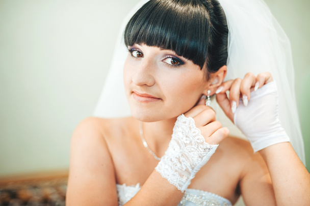 beautiful bride getting ready in white wedding dress with hairstyle and bright makeup. Happy sexy girl waiting for groom. Romantic lady in bridal dress have final preparation for wedding. - Fotografie, Obrázek
