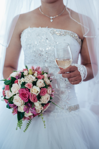 όμορφη νύφη ετοιμάζεται σε άσπρο γαμήλιο φόρεμα με χτένισμα και φωτεινό μακιγιάζ. Ευτυχισμένος σέξι κορίτσι σας περιμένουν για γαμπρό. Ρομαντική κυρία στο νυφικό φόρεμα έχουν τελική προετοιμασία για το γάμο. - Φωτογραφία, εικόνα