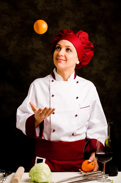 Chef juggling with orange - Фото, изображение