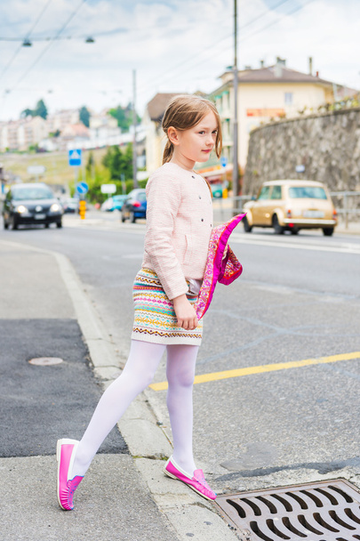 Retrato de moda de una linda niña en una ciudad, con zapatos rosas, falda y chaqueta
 - Foto, Imagen
