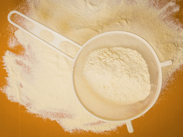 Sifting wheat flour on orange mat - Foto, immagini
