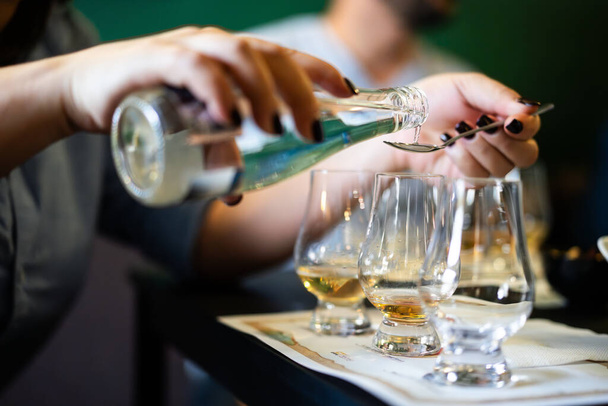 Persona que añade agua en vaso de whisky de malta simple Glencairn. - Foto, imagen