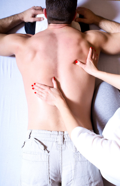 A young man receiving a massage - Фото, изображение