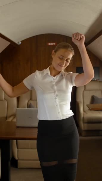 Gelukkige succesvolle zakenvrouw dansen in prive jet cabine. Exclusieve valk privé mini jet voor zakenreizen. 4k UHD. Verticaal schot. - Video