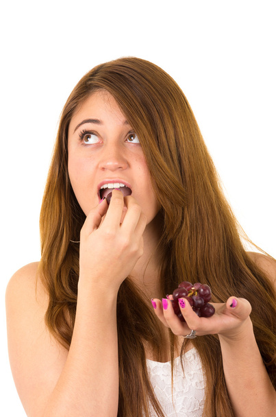 Beautiful young supersticious woman eating grapes - Foto, Bild