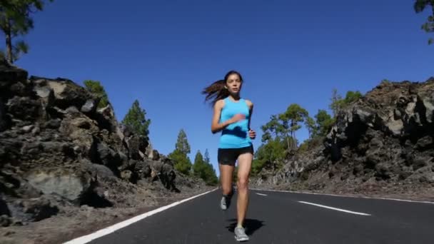 Vrouw joggen op bos bergweg - Video