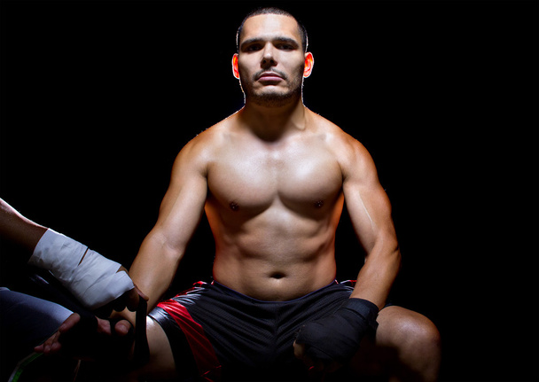 Boxeador con entrenador aplicando cinta atlética
 - Foto, Imagen