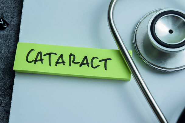 Koncept zápisu katarakty na lepkavé poznámky se stetoskopem izolované na dřevěném stole. - Fotografie, Obrázek