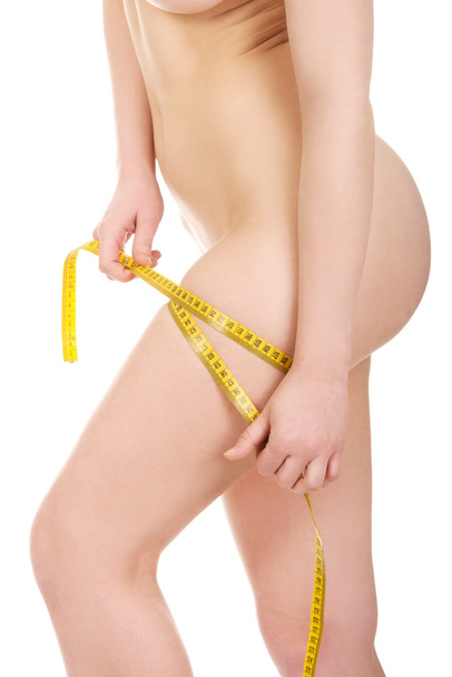 Slim woman measuring her thigh. - Foto, afbeelding