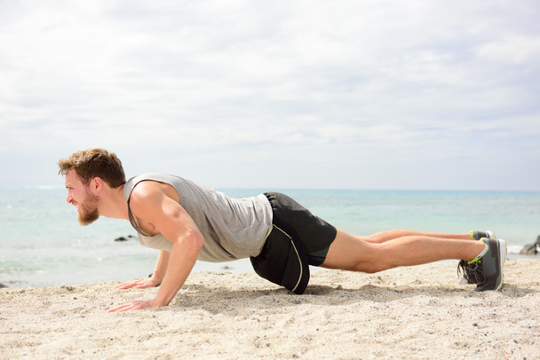 Man fitness exercising on beach - Fotó, kép