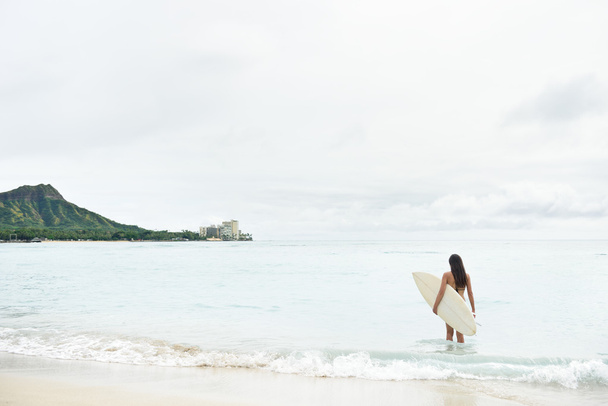 Girl going surfing on Waikiki Beach - 写真・画像