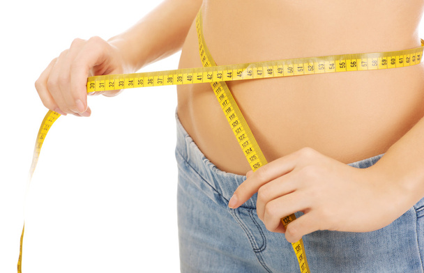 Slim woman measuring her waist. - Valokuva, kuva