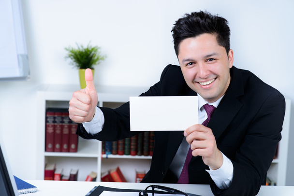 attractive business man in office holding a blank card - Фото, изображение