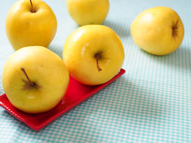 Yellow apples on red plate - Photo, Image