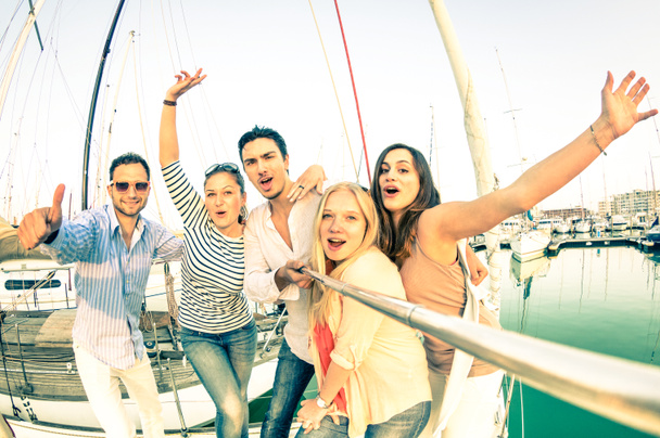 Beste vrienden met behulp van selfie stok nemen van pic op exclusieve luxe zeilboot - Concept van vriendschap en reizen met jonge mensen en nieuwe technologie trends - heldere nostalgische desaturated kleurtonen - Foto, afbeelding