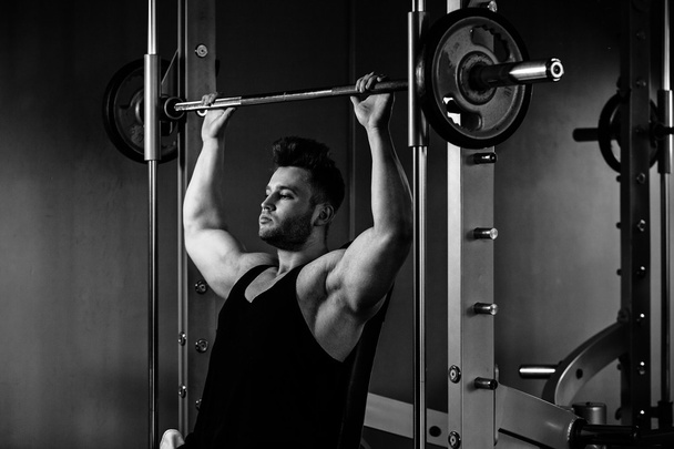 bodybuilder guy in gym with heavy weights  monochrome - Foto, Imagem