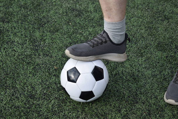 Молодий чоловік у спортивному одязі грає у футбол, тренується на футбольному полі вранці. Відданість і пристрасть до спорту, суть ранкових вправ і практики на відкритому повітрі - Фото, зображення