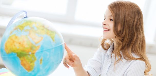 smiling student girl with globe at school - 写真・画像