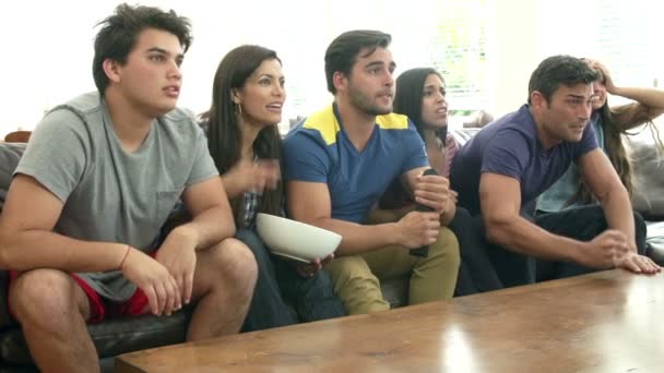 Gruppe von Freunden auf dem Sofa sitzen und gemeinsam fernsehen - Filmmaterial, Video