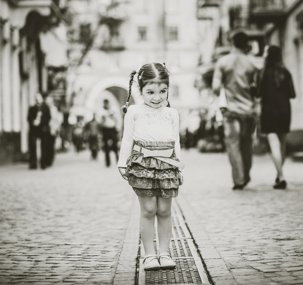 Little pretty girl walking on the city street - Photo, Image