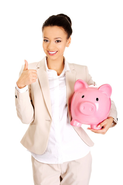 Businesswoman with piggybank and thumbs up. - Foto, immagini