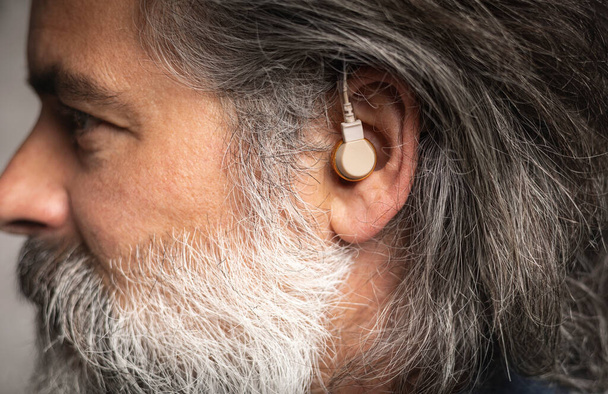 Hearing aid in the ear of a middle-aged man - Photo, Image