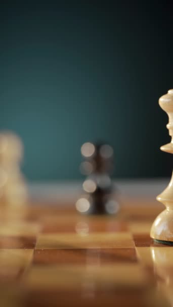 Focus on a white king chess piece on a wooden chessboard with blurred background and other chess pieces. - Footage, Video