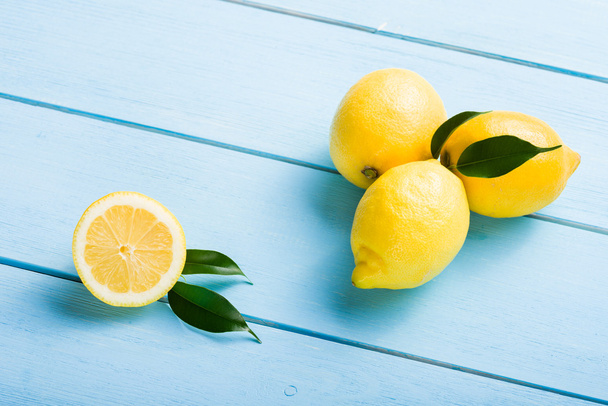 Fresh lemons on blue wooden table - Foto, imagen