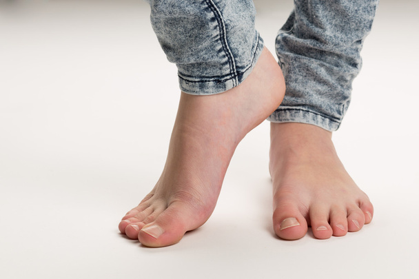 Δύο γυμνά πόδια μόνιμης μύτες των ποδιών στο πάτωμα - Φωτογραφία, εικόνα