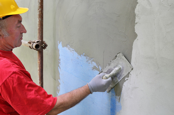 Wall insulation, spreading mortar over mesh - Fotoğraf, Görsel