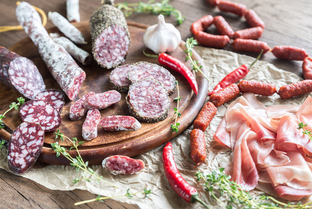 Different kinds of sausage on the wooden background - Фото, зображення