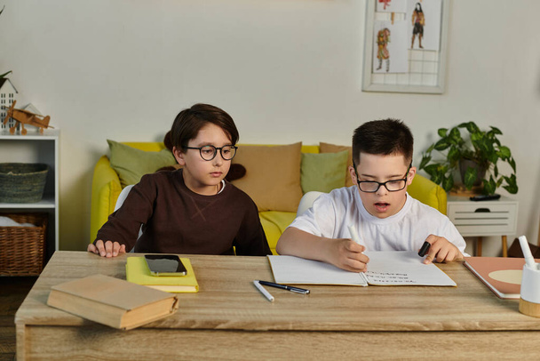 Two young boys study together at a table in a living room. - Foto, immagini
