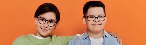 Két fiatal fiú mosolyog a kamerába, az egyik Down-szindrómás.. - Fotó, kép