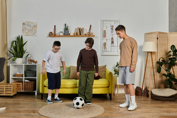 Tres jóvenes jugando con una pelota de fútbol dentro de una casa. - Foto, Imagen