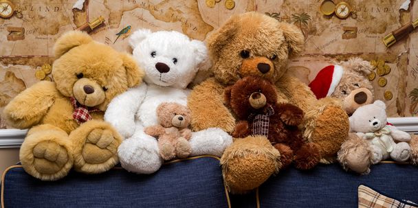 Een groep van cute teddy draagt samen zitten op de Bank - Foto, afbeelding