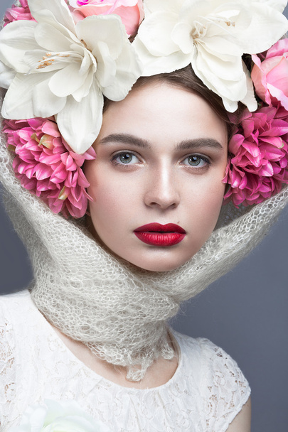 Beautiful girl in a headscarf in the Russian style, with large flowers on his head and red lips. Beauty face. - Fotó, kép
