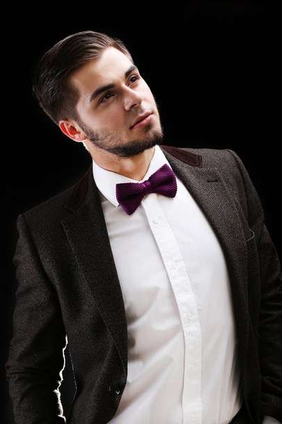 Elegant man in suit on dark background - Foto, imagen