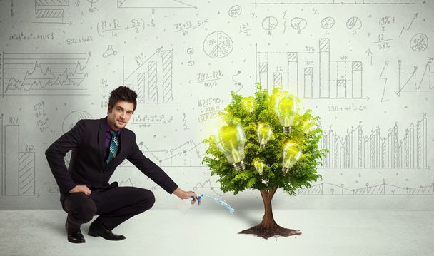 Business man pouring water on lightbulb growing tree - Photo, Image