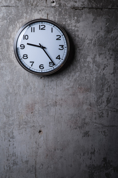 Reloj de pared redondo colgado en la pared de hormigón gris
 - Foto, imagen